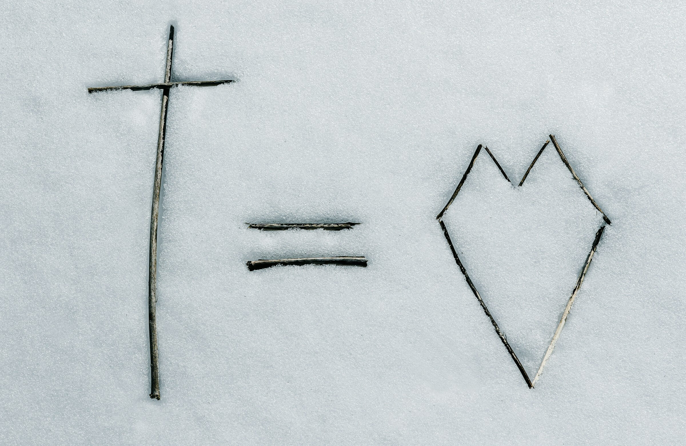 Cross equals heart drawn in the snow